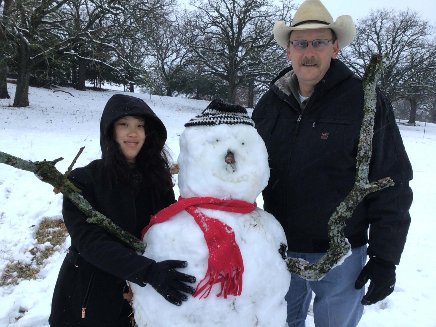 Sheriff Adam King building a snowman with his daughter